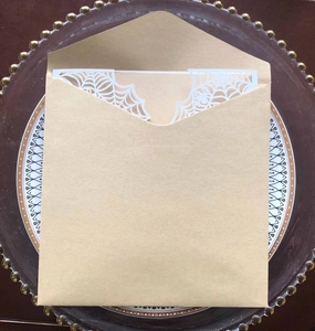 Detail showing laser-cut spider web card and kraft envelope on decorative glass tray