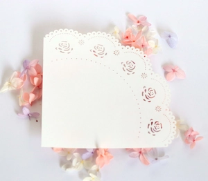 Detailed laser-cut white wedding cone paper with delicate rose floral lace patterns