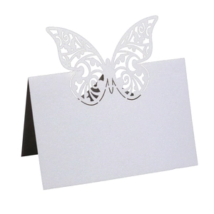 Detail of laser-cut white butterfly place card with intricate patterns for wedding decor