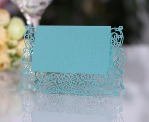 Detail of light blue laser-cut place card with ornate patterns and heart design
