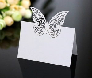 Close-up of a laser-cut white butterfly place card with elegant hollow pattern
