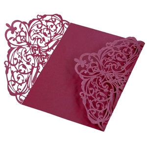 Detail of laser-cut burgundy wedding invitation with elegant floral lace pattern