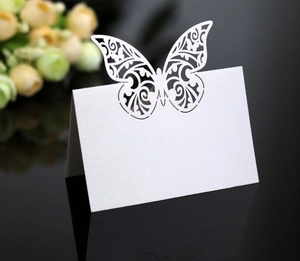 Macro detail of white pearlescent paper butterfly place card with laser cut pattern