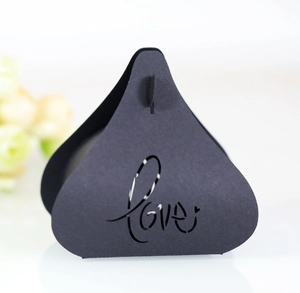 Détail d'une boîte cadeau triangulaire noire mate avec motif LOVE ajouré au laser