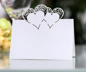 Macro detail of laser-cut double heart place card in white textured paper
