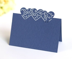 Detail of laser-cut heart place card in navy blue cardstock for wedding table settings