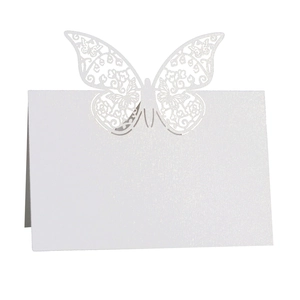 Macro detail of laser-cut butterfly place card featuring intricate floral hollow patterns