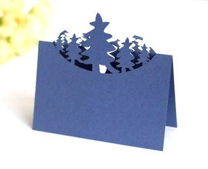 Detail of 3D laser-cut pine tree silhouettes on dark blue cardstock for table settings