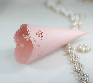 Pink laser-cut wedding paper cones with heart hollow designs and floral petal patterns