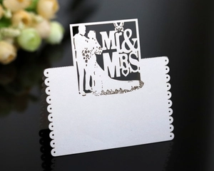 Detail of laser-cut Mr & Mrs wedding table card with elegant silhouettes on pearl paper