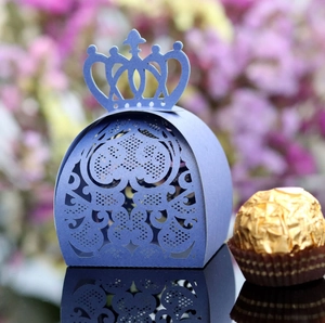 Close-up of laser-cut crown candy box with intricate lace patterns in deep blue