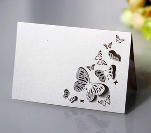 Detail view of laser-cut butterfly hollow pattern on elegant white pearlescent paper card