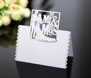 Macro detail of laser-cut Mr & Mrs wedding place card with elegant couple silhouette