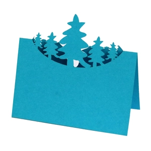 Detailed macro view of laser-cut 3D blue Christmas tree forest place card with layers
