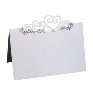 Detailed laser-cut heart design on white pearlescent paper wedding table card