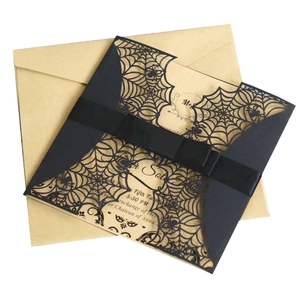 Elegant black laser-cut spider web invitation with a satin ribbon and kraft paper card
