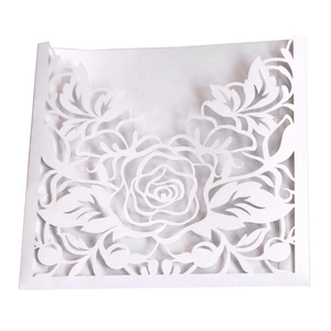Détail du faire-part de mariage blanc découpé au laser avec un motif élégant de rose