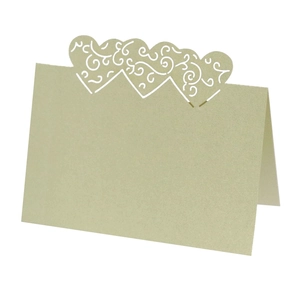 Macro detail of laser-cut heart pattern on pearlescent light green hollow table cards