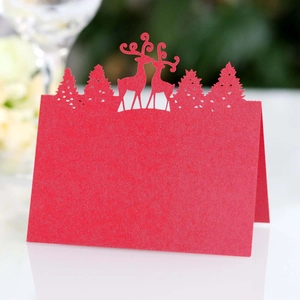 Detailed laser-cut Christmas reindeer place card in festive red on a dinner table