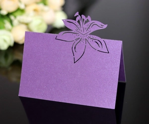 Detail of laser-cut purple pearl paper place card with lily floral hollowed pattern