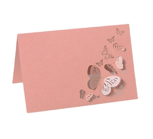 Detailed view of pink laser-cut 3D butterfly place cards on white background