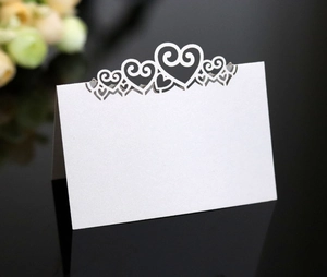 Detail of elegant heart laser-cut name card in pearlescent white for wedding table decor