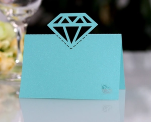 Close-up of light blue laser-cut place card with diamond cutout for wedding table decor