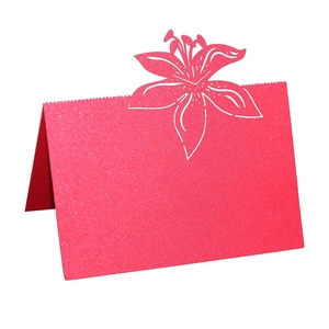 Close-up of pink glitter place card with laser-cut lily flower for wedding tables