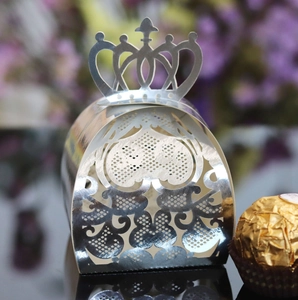 Macro detail of silver crown laser-cut wedding candy box with heart patterns