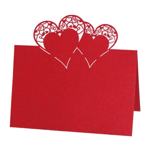 Detailed laser-cut hollow red heart place card with intricate floral patterns for weddings