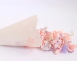 Macro shot of off-white laser-cut wedding flower cones with delicate rose lace edges