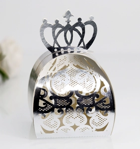 Macro view of silver laser-cut crown favor box with intricate heart hollow patterns