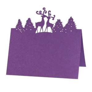 Detail showing a dark purple laser-cut reindeer and pine tree place card for tables