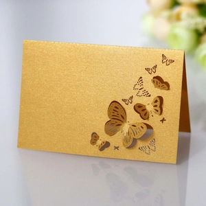 Macro detail of golden butterfly place cards with laser-cut hollow design for weddings