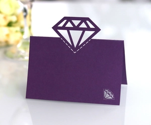 Detail of dark purple place card with laser-cut diamond shape for elegant weddings