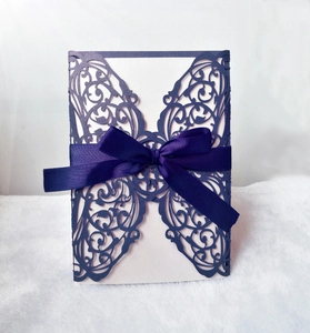 Detail of laser-cut purple butterfly invitation cover with elegant satin ribbon bow