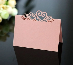 Detailed laser-cut heart design on pale pink pearlescent place card for weddings