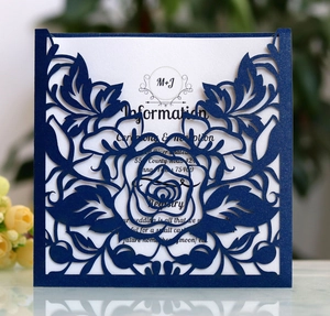 Detail of laser-cut navy blue wedding invitation with intricate rose hollow patterns