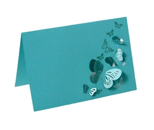Detail of teal blue place card featuring a laser-cut 3D hollow butterfly design