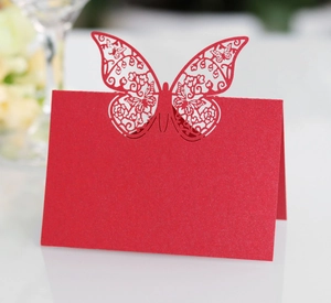 Macro view of a red laser-cut butterfly table place card for wedding reception events