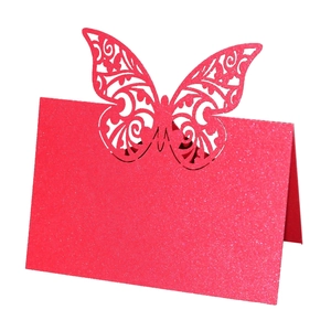 Detailed laser-cut butterfly place card in glittery pink paper for wedding tables