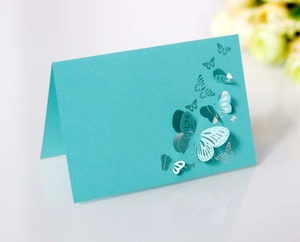 Detail view of teal laser-cut place card featuring elegant 3D hollow butterfly design