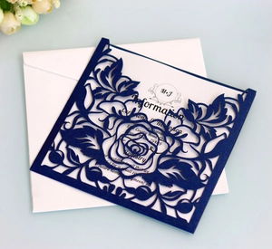 Detail of laser-cut navy floral wedding invitation with inner card and envelope