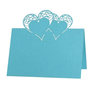 Detailed laser cut heart-shaped patterns on light blue hollowed table place cards