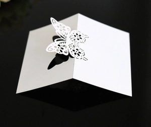 Detailed laser-cut 3D butterfly place card in white with intricate floral hollow patterns