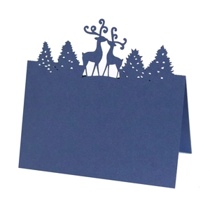 Close-up of laser-cut reindeer and pine tree silhouettes on dark blue cardstock