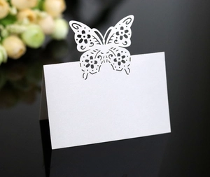 Detailed laser-cut butterfly place card in pearl white for elegant wedding table settings