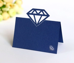 Detail of dark blue laser-cut place card with diamond hollow design for wedding table