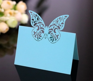 Detail of light blue laser-cut butterfly place card with elegant hollow pattern
