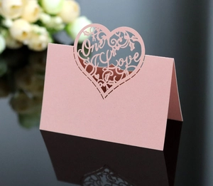 Detail of pink laser-cut place card with One Love heart design and pearlescent finish